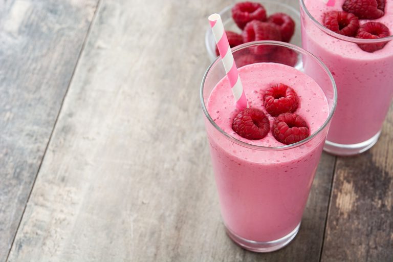 Raspberry,Smoothie,In,Glass,On,Wooden,Table