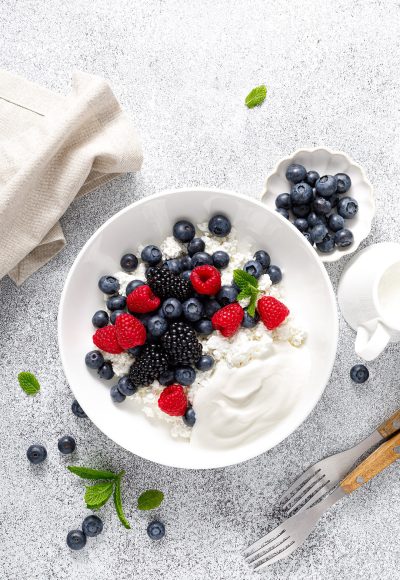 Cheese cottage with yogurt and fresh berries. Curd with blueberry, raspberry and blackberry, top view