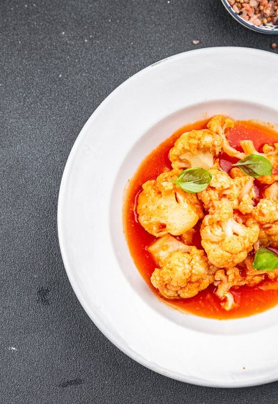 cauliflower in tomato sauce stewed vegetable second course healthy eating appetizer meal food snack on the table copy space food background rustic top view keto or paleo diet vegetarian vegan