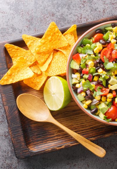 Cowboy caviar or Texas salad made with beans, corn, bell peppers, and tomato in chili lime vinaigrette for a delicious party appetizer closeup in the bowl on the table. Horizontal top view from above