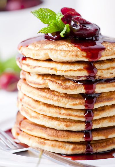 Bunch of homemade pancakes with cherry topping