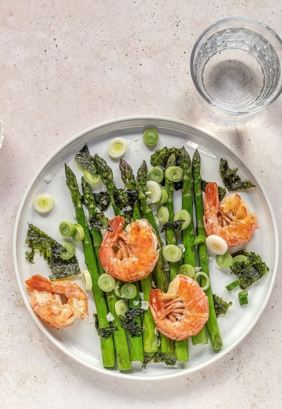 For healthy eating: Seasonal salad with grilled shrimps, green asparagus, onion, nori, and pepper oil dressing. Top view, ready to eat.